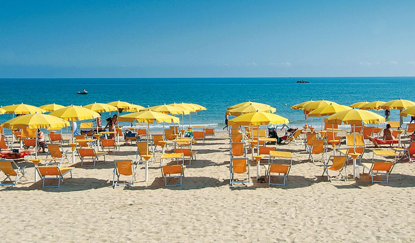 Der Strand mit Sonnenschirme und Liegestühle