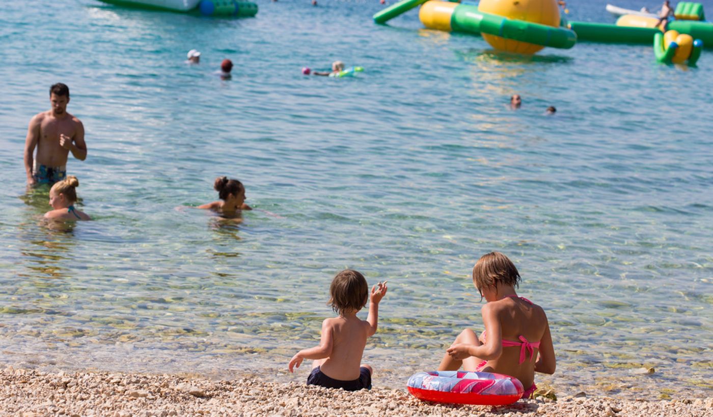 Kinder die am Strand in Krk in Kroatien spielen