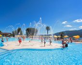 eine Gruppe von Menschen, die in einem Pool spielen, mit einem Springbrunnen im Hintergrund